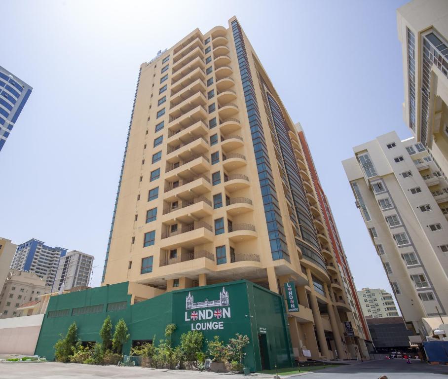 a tall building in the middle of a city at Al Manzil Hotel Bahrain in Juffair