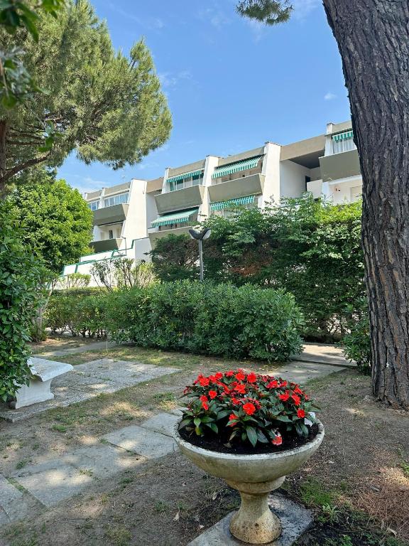 a planter with red flowers in front of a building at Residence MARE App Alga 24 in Lido delle Nazioni