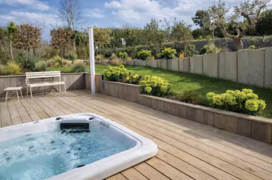 a hot tub on a deck with a garden at Villa Bleu Horizon in Carantec