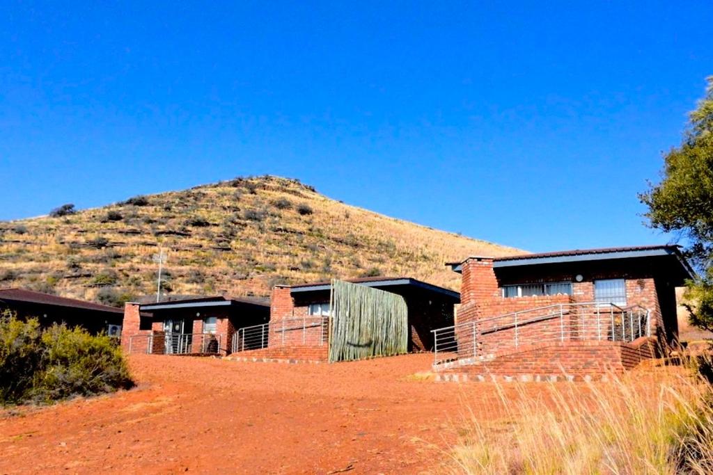 a group of buildings with a mountain in the background at Wonderwerk cave adventures in Kuruman
