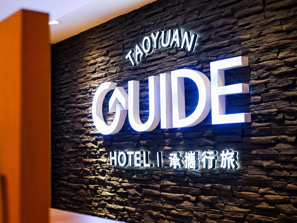 a sign for a hotel on a brick wall at Guide Hotel Taoyuan Fuxing in Taoyuan