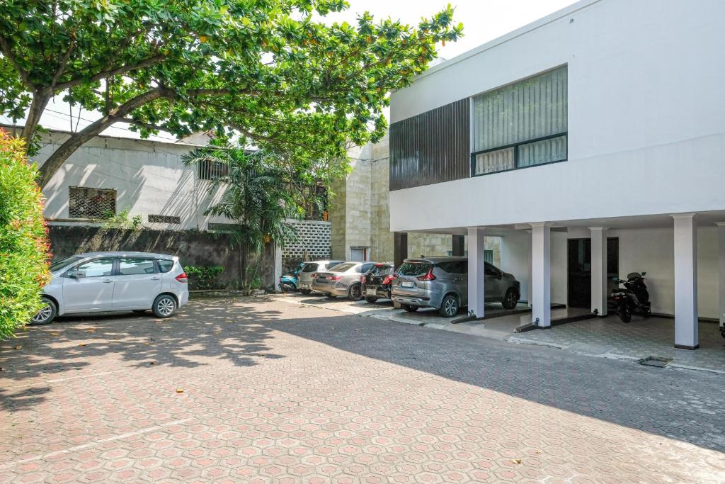 a parking lot in front of a building with cars parked at Hotel Srikandi Semarang RedPartner in Candi