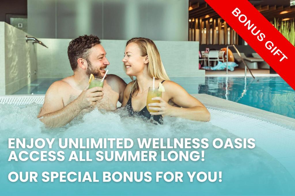 a man and woman in a swimming pool with drinks at Jurmala Spa Hotel in Jūrmala