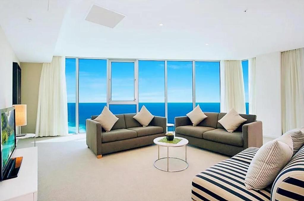 a living room with two couches and a view of the ocean at Luxurious 2 Bedroom Apartment - Ocean View in Gold Coast