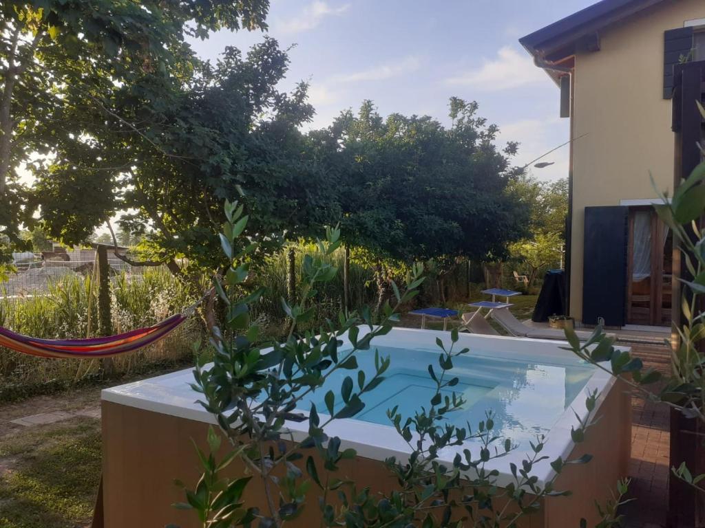 a swimming pool in a garden with a hammock at Country House Salomè in Musile di Piave