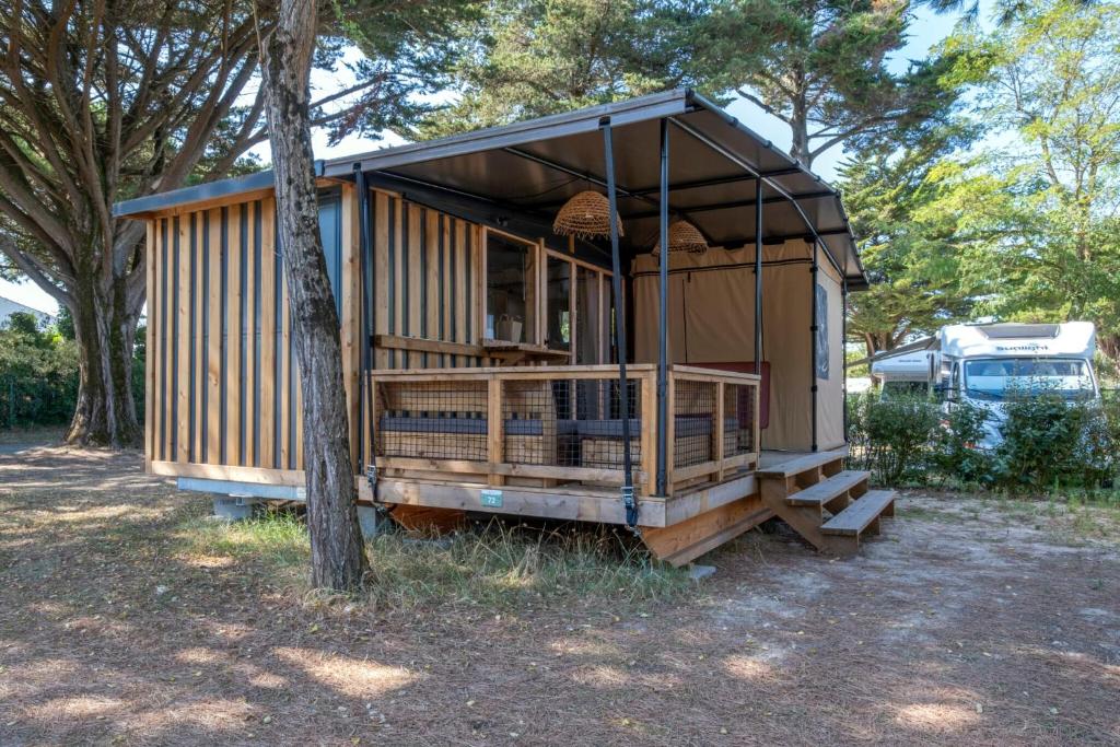 a tiny house sitting next to a tree at Camping du Lac de Cazaux in La Teste-de-Buch