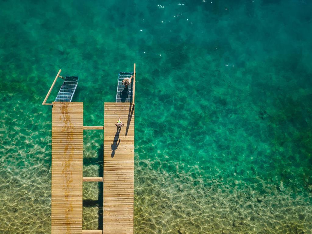 a man standing on a dock in the water at Hotel Seerose in Fuschl am See