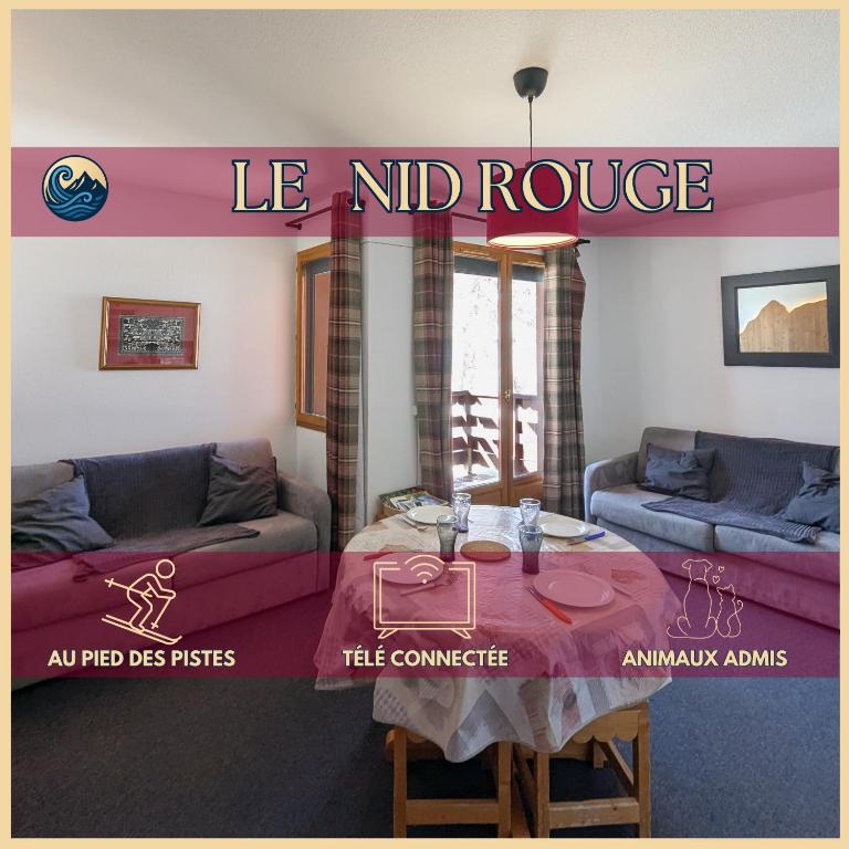 a living room with a table and couches and a sign at Le Nid Rouge Risoul Balcony & View Ski 100 m in Risoul