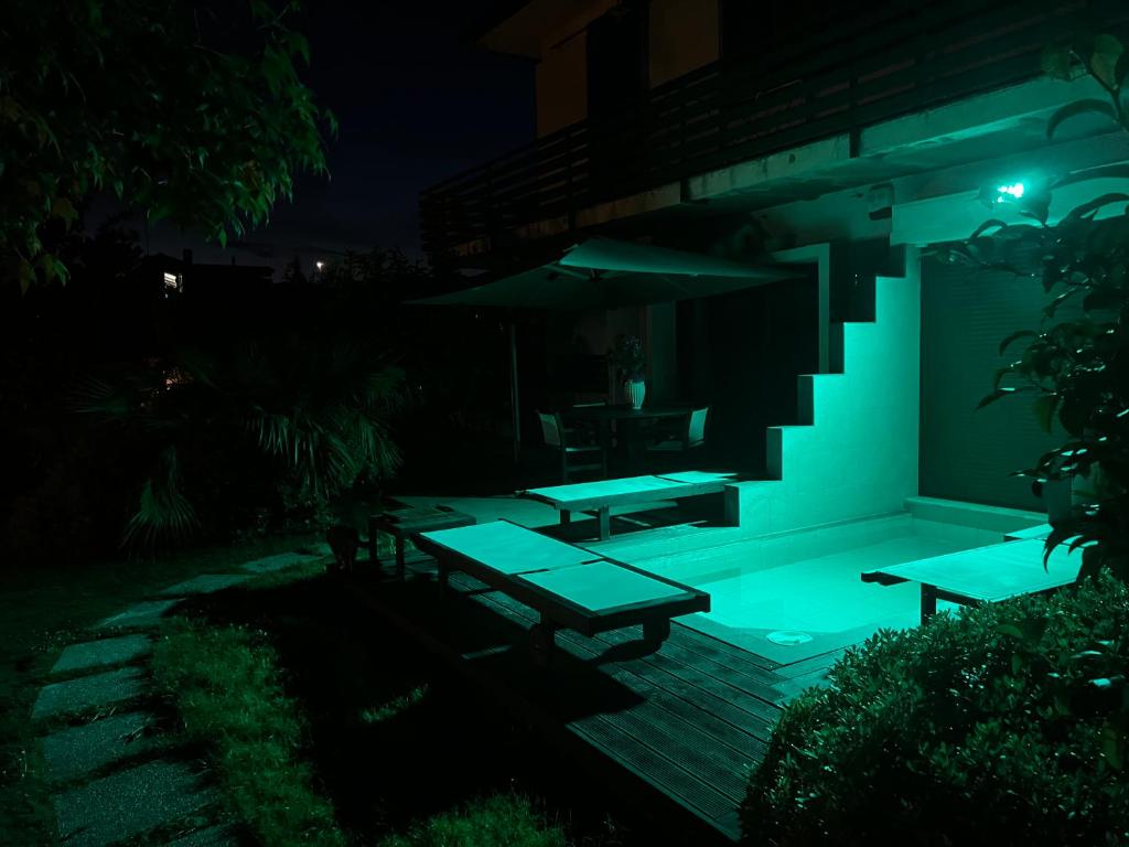 a patio with two picnic tables and a staircase at night at Studio Naty in Marina di Massa