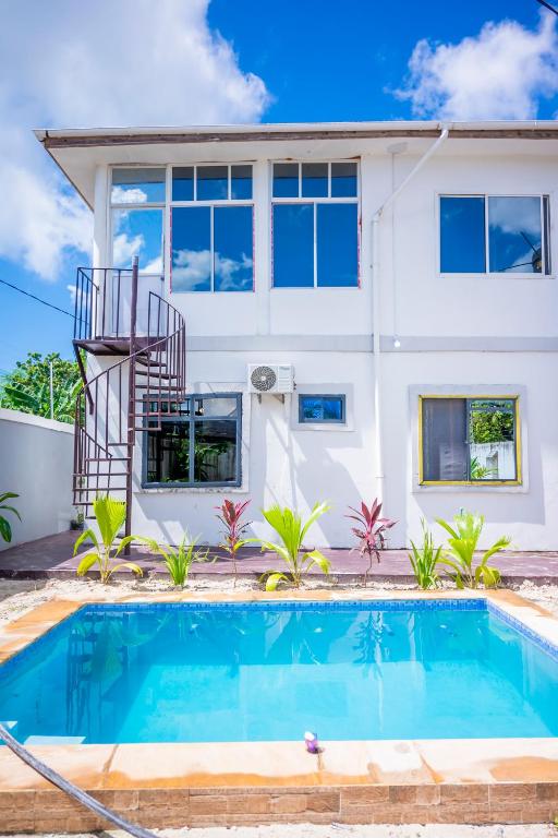 a house with a swimming pool in front of a house at Marumbi Beach House in Marumbi