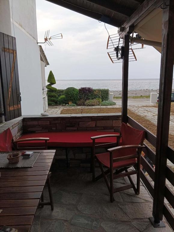 a porch with a bench and chairs and the ocean at Chorefto Waves in Chorefto