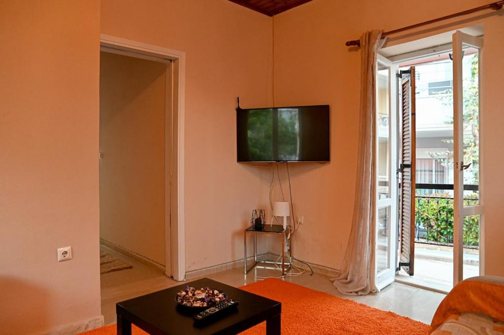 a living room with a flat screen tv on the wall at BotaniCasa by WENS in Preveza