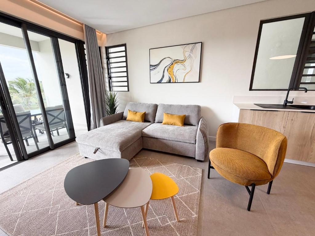 a living room with a couch and a table and chairs at Asmara Residence 2 Bedroom Apartment by LOV Mauritius, Beach Access in Petite Case Noyale