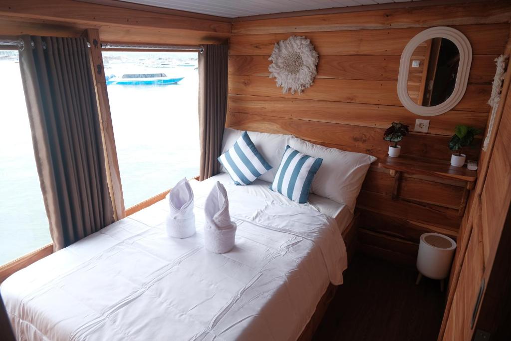 a bedroom with a bed with two towels on it at Phinisi Private trip Komodo Island in Komodo Labuan Bajo Airport