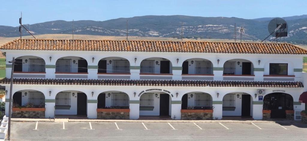 an old white building with a lot of windows at Hotel Apolo XI in Tahivilla