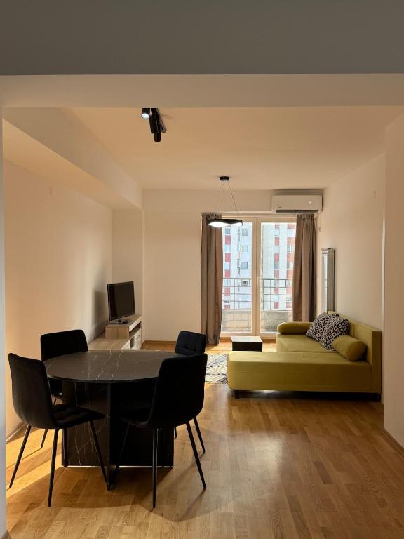 a living room with a table and a couch at Skopje Riverfront Modern Apartment in Skopje