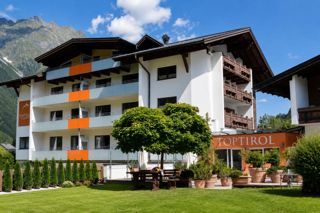 a hotel building with a picnic table in front of it at Top Tirol Appartement in Längenfeld