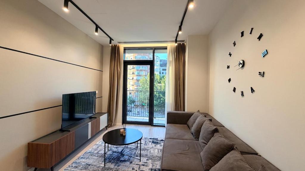 a living room with a couch and a tv at Dream Suites - Lake View Residences in Tirana
