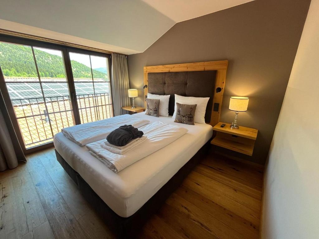 a bedroom with a large bed with a large window at Zugspitzblick - pur! in Lermoos