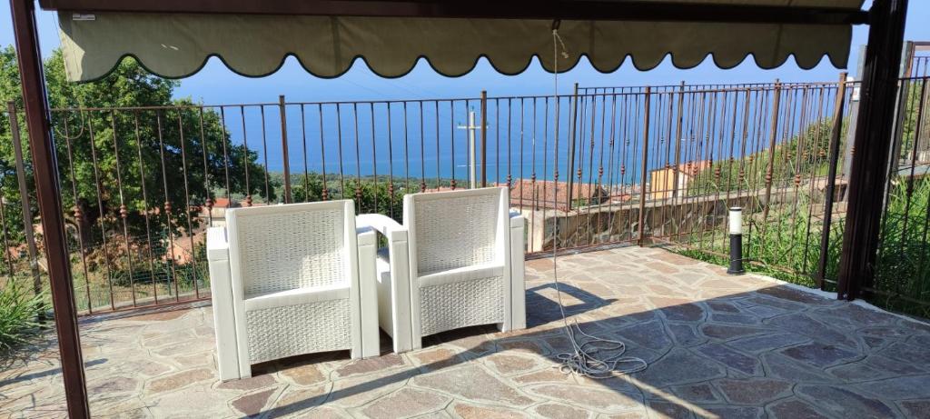 two white chairs sitting in front of a fence at Casa Vacanze Sofì in Ascea