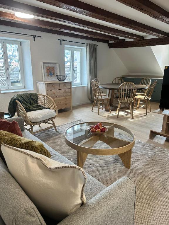 a living room with a couch and a table and chairs at Stadtloft Suites Richterswil in Richterswil