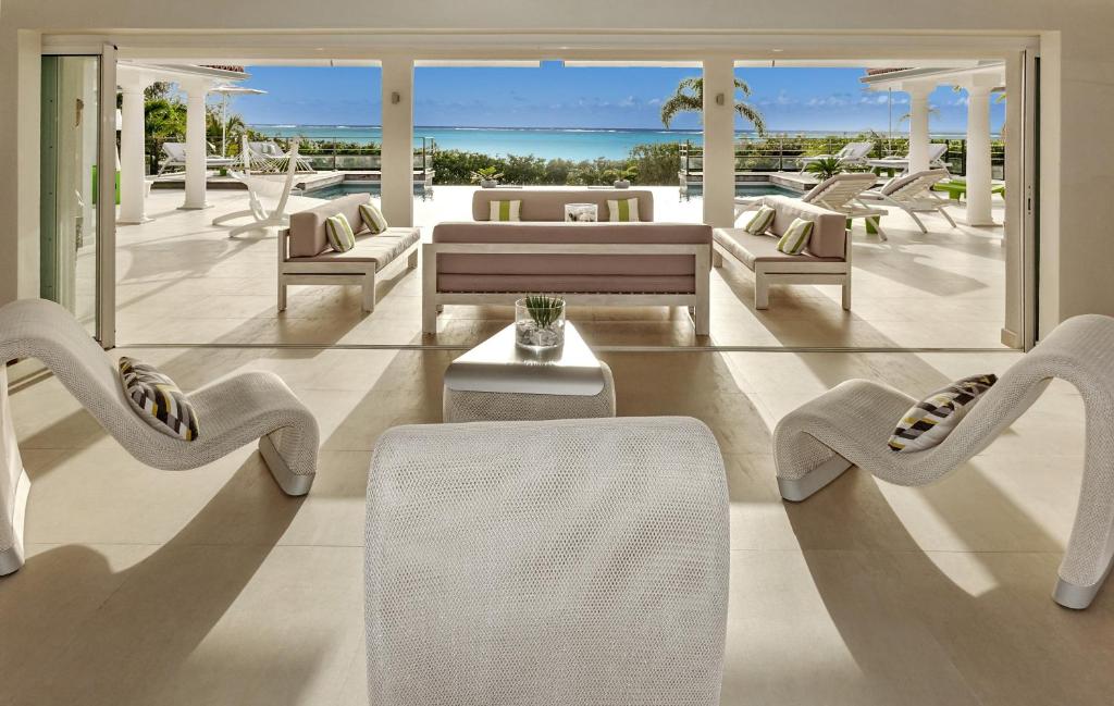 a living room with white furniture and the ocean at Seafacing Villas Apartments Rentals in Les Terres Basses