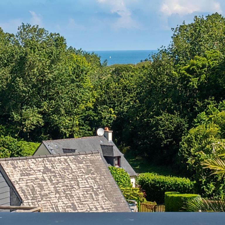 a roof of a house with the ocean in the background at Kub in Trélévern