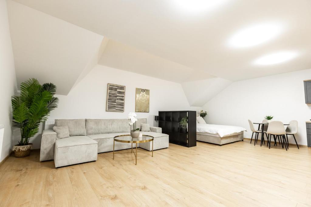 a white living room with a couch and a table at Apartmani Triluna in Drškovci