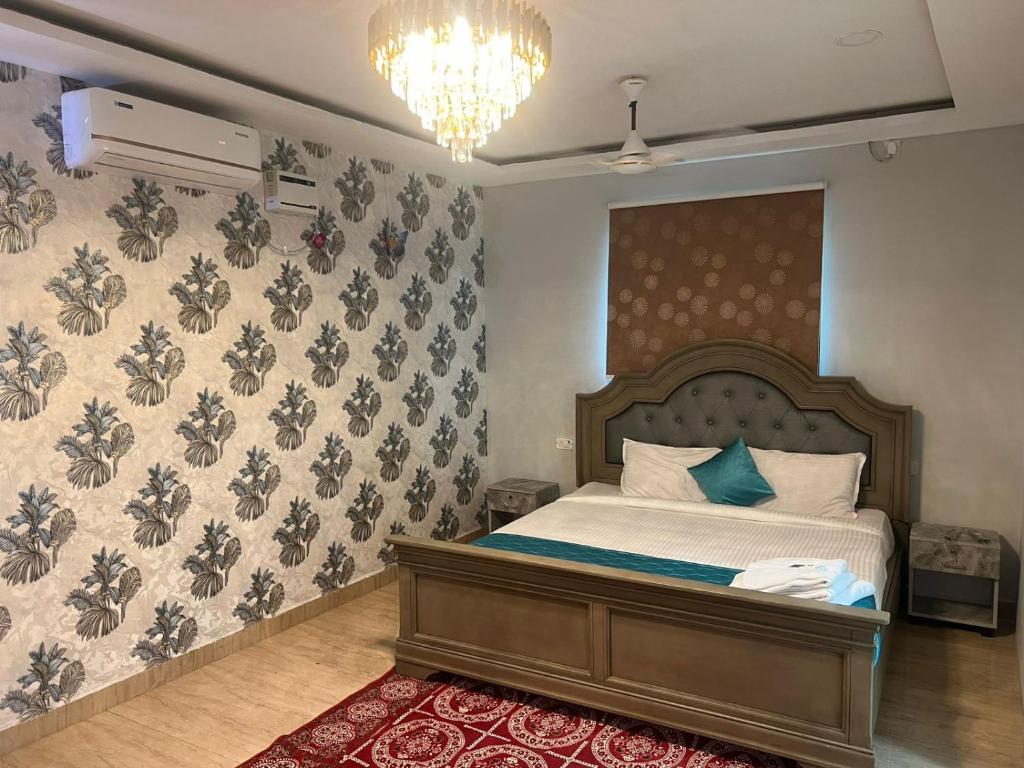 a bedroom with a bed and a chandelier at Aerodon resort in Chennai