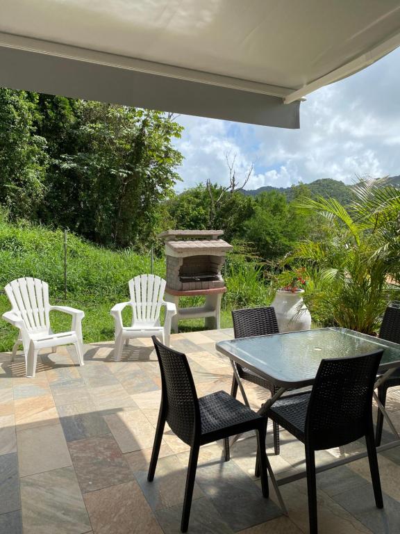 a patio with chairs and a table and a grill at La Marlyse in La Vatable
