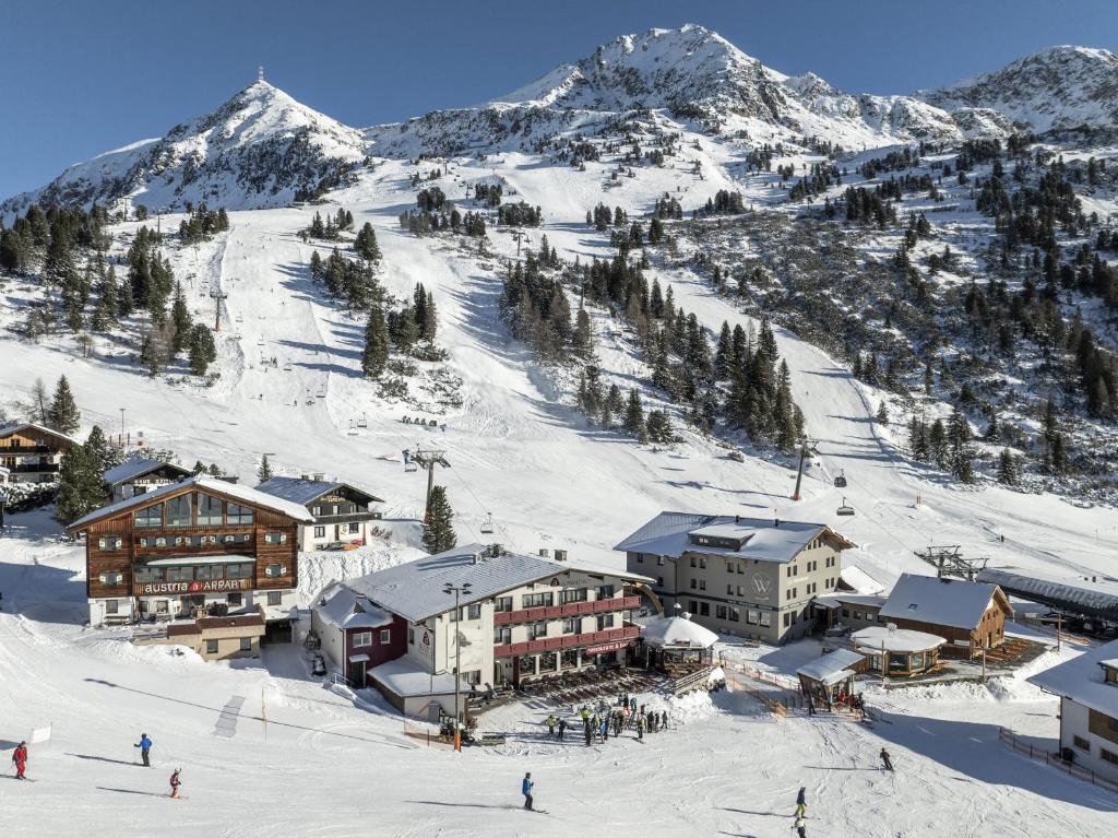 a ski resort with people skiing on a snow covered mountain at Austria Alpinhotel Ski IN Ski OUT an der Edelweissbahn in Obertauern