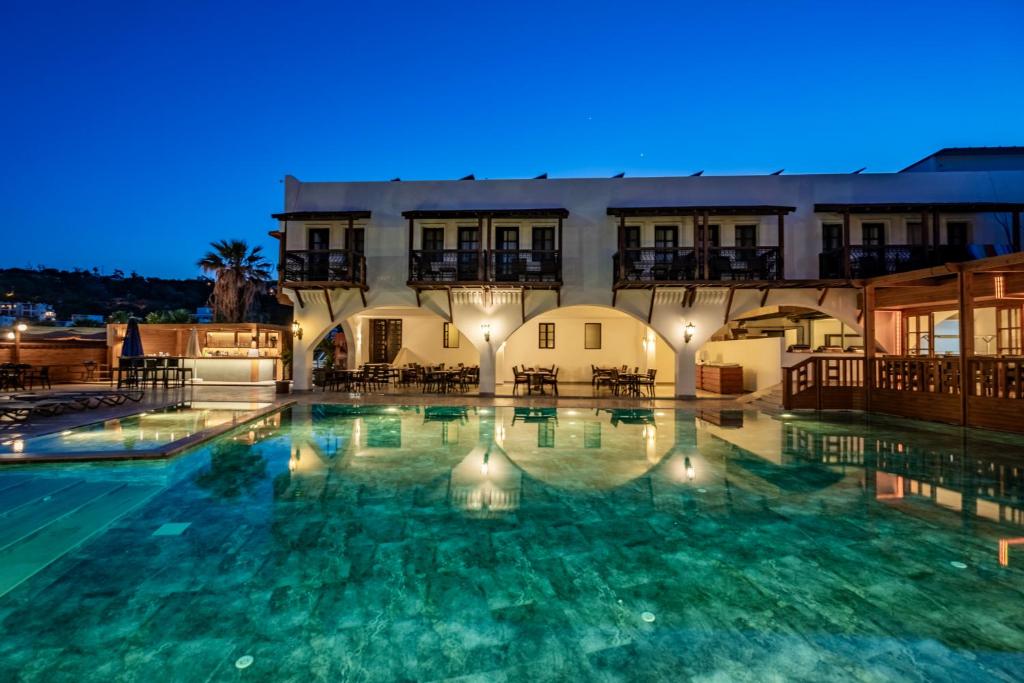ein großes Schwimmbecken vor einem Gebäude bei Nacht in der Unterkunft Costa Bitezhan Beach Hotel in Bitez