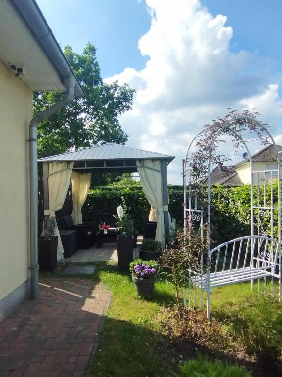 a garden with a pergola and a patio at Ferienwohnung Tukan in Walsrode