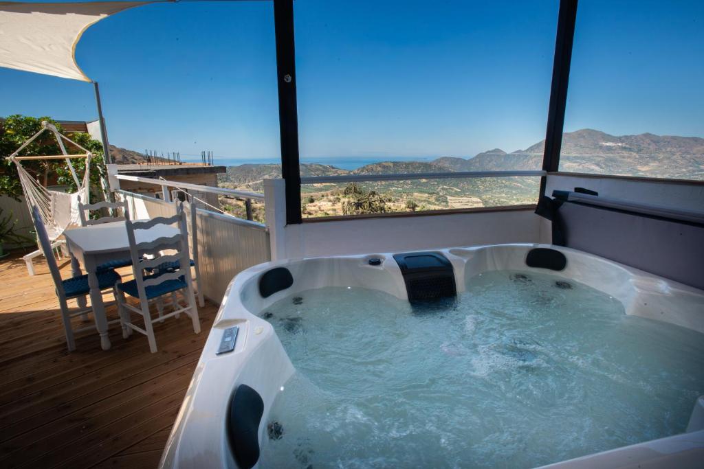 a jacuzzi tub on a balcony with a view at EMPHASIS Traditional House with Jacuzzi & Bicycles in Apodhoúlou