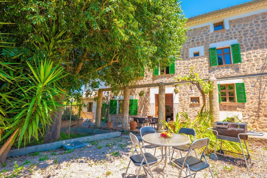 a patio with a table and chairs in front of a building at Can Raia in Sóller
