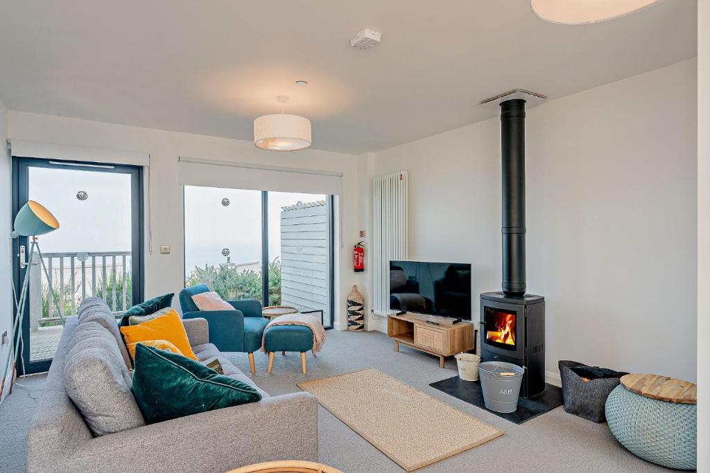 a living room with a couch and a fireplace at Residence Number 5 - Luxury 2 Bed Ground Floor Apartment By Together Travel in Nefyn