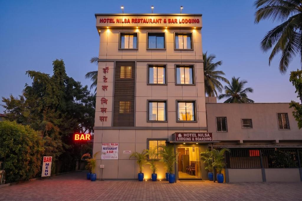 a building with a sign on top of it at FabHotel Nilsa in Pālghar