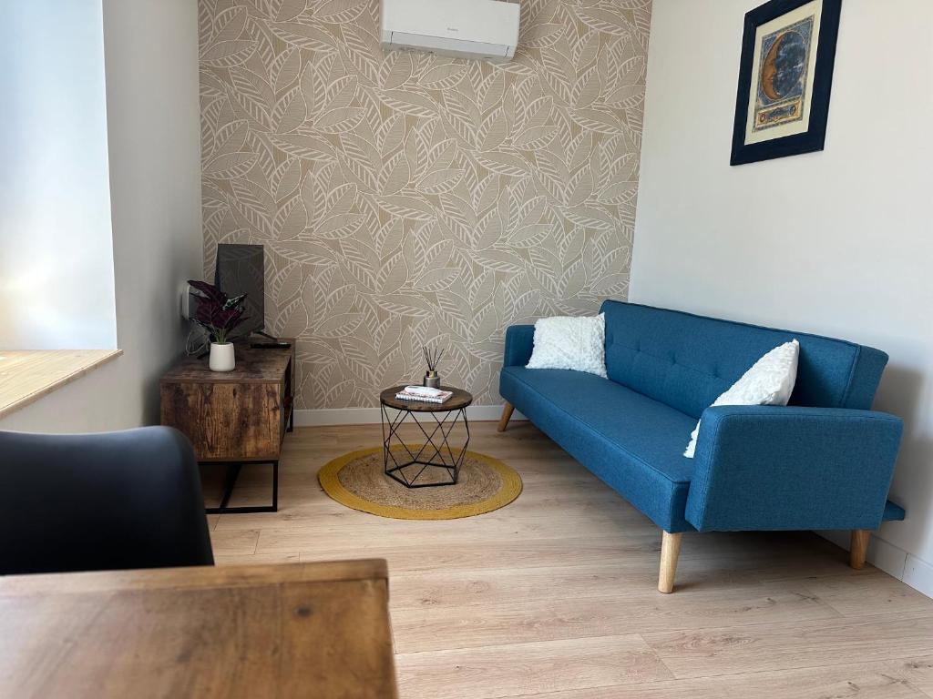 a living room with a blue couch and a table at Résidence le 1564 Bleu in Roussillon en Isere