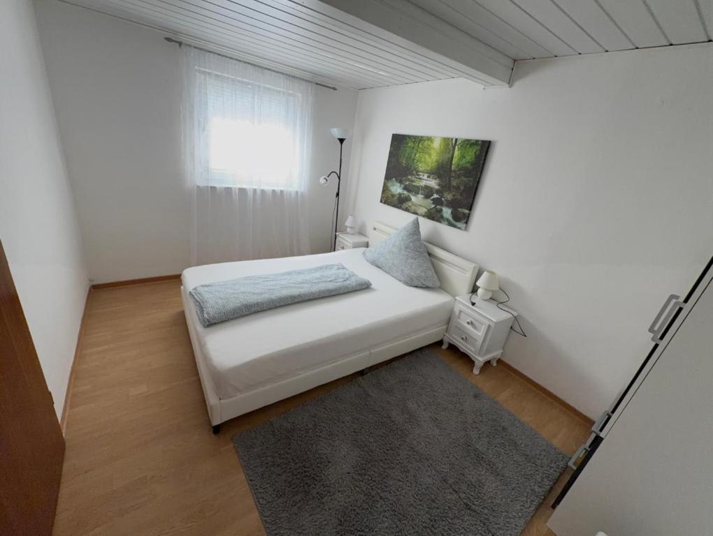 a white bedroom with a bed and a window at Zentral Z in Siegen