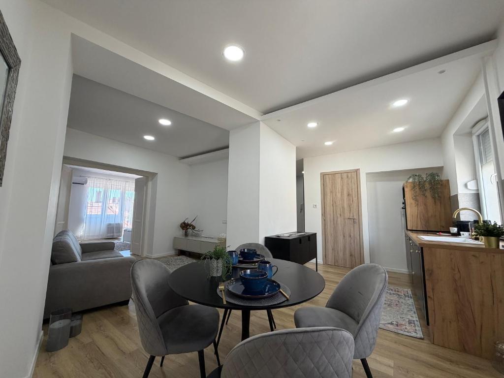 a living room with a table and chairs at Sopianae Apartments in Pécs