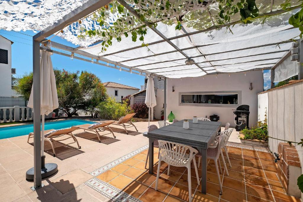 a patio with a table and chairs and a pool at Les Arbousiers in Saint-Raphaël
