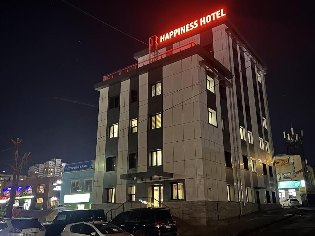 a building with a neon sign on top of it at Happiness Hotel Ulaanbaatar in Ulaanbaatar