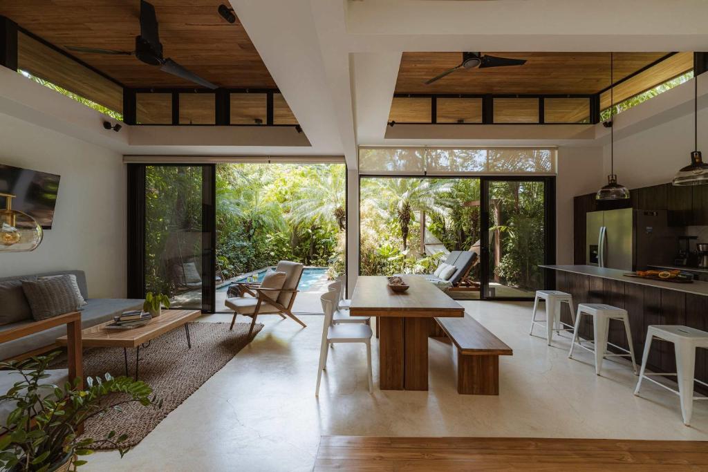 a kitchen and living room with a table and chairs at Nalu Nosara Pool Villa Flor in Nosara