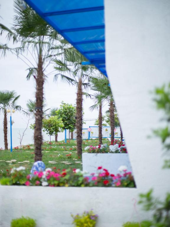 a view of a park with palm trees and flowers at Relax Beach Astara in Astara