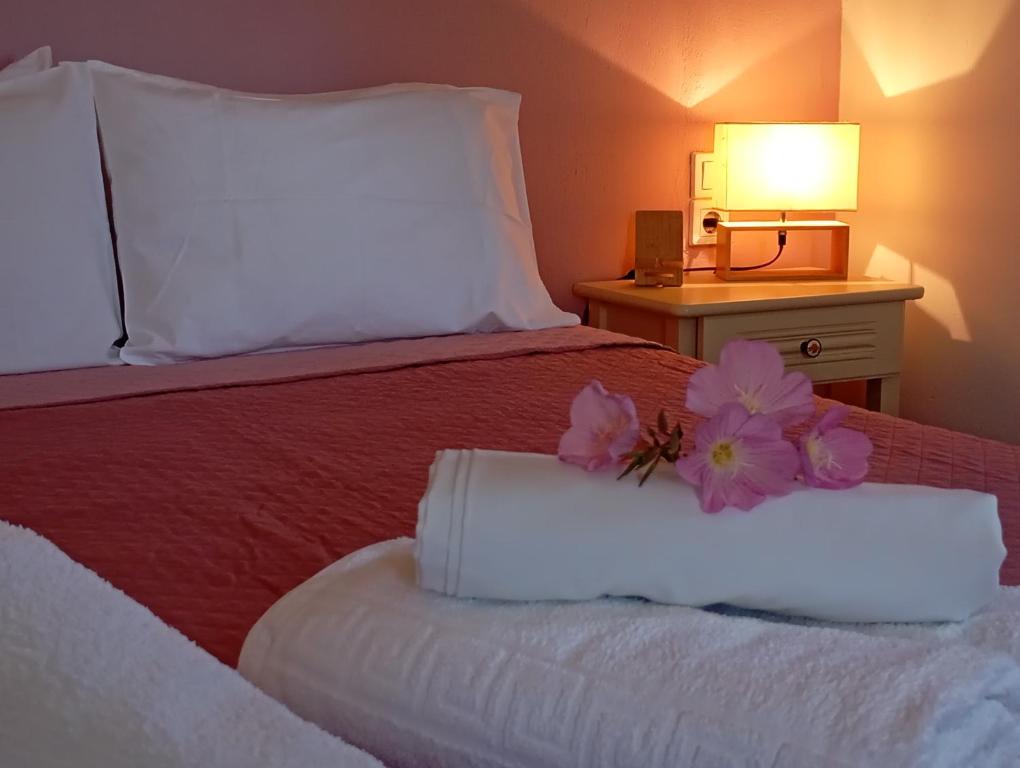 a hotel room with a bed with a flower on it at Villa Pefkias in Skopelos Town