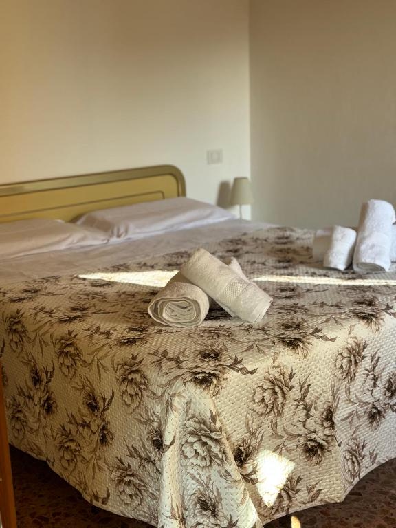 a bed with a blanket and two towels on it at Casa Ravasio in Arcevia