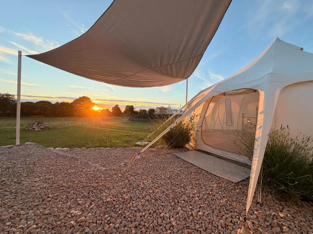 a tent with the sunset in the background at Lisinj Sky Glamping in Bar