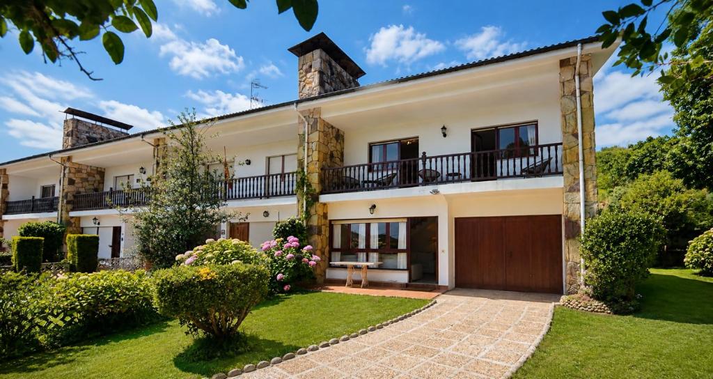 an exterior view of a house with a yard at Villa Toro Playa Llanes a 100 m de la playa in Llanes