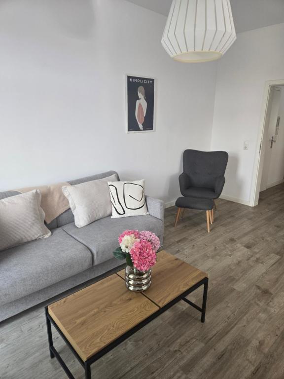 a living room with a couch and a table with flowers on it at Der Stader Fernblick in Stade