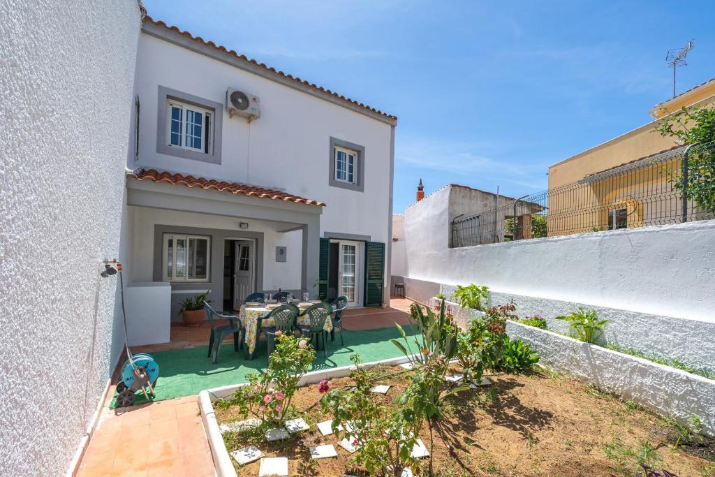 a house with a patio with a table at Casa Sol in Praia do Carvoeiro